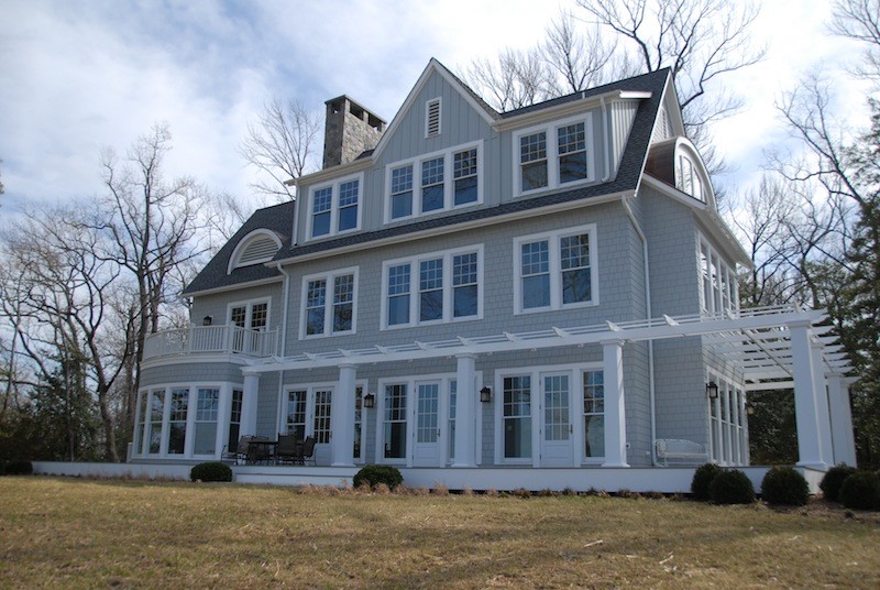 Cette image montre une très grande façade de maison bleue traditionnelle en panneau de béton fibré à deux étages et plus avec un toit en shingle.