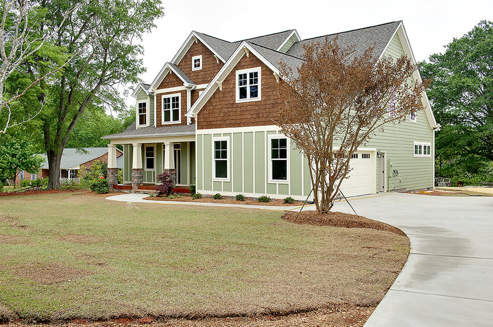 Стильный дизайн: двухэтажный, зеленый, деревянный дом в стиле кантри с двускатной крышей - последний тренд