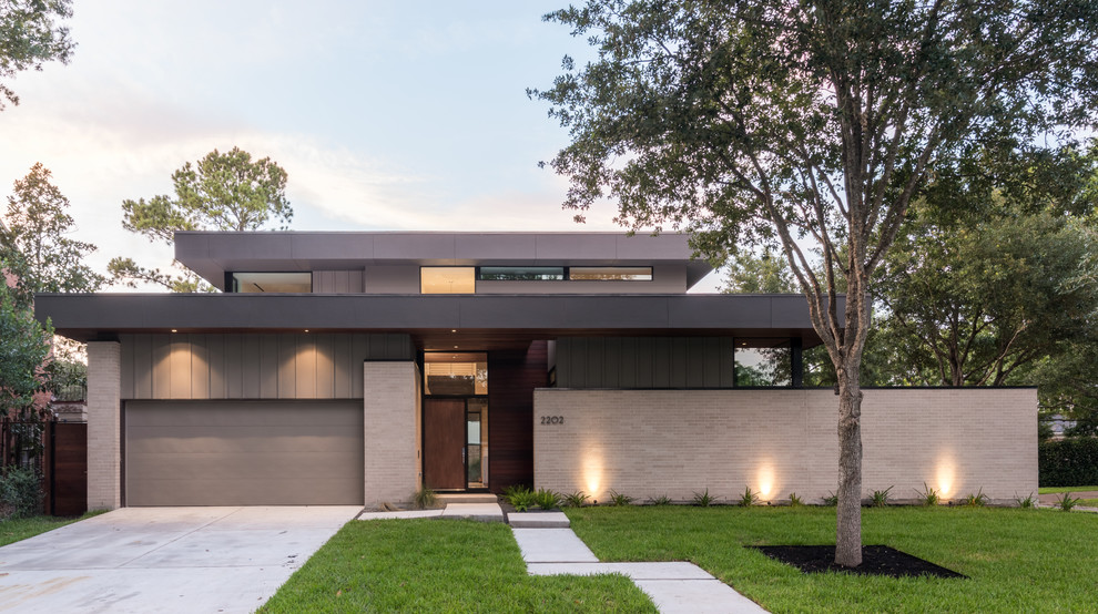 Mittelgroßes, Zweistöckiges Modernes Einfamilienhaus mit Backsteinfassade, grauer Fassadenfarbe und Flachdach in Houston