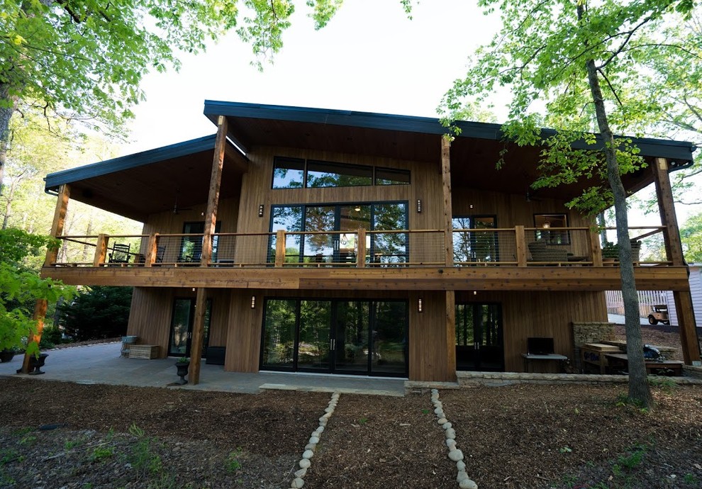 Réalisation d'une façade de maison marron minimaliste en bois de taille moyenne et à un étage avec un toit en appentis.