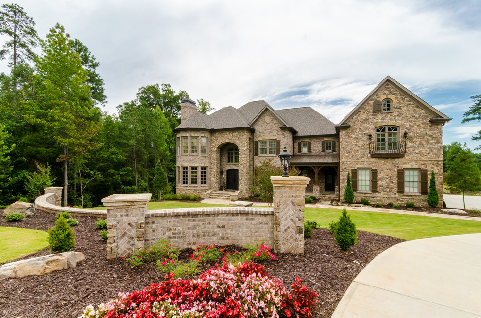 Design ideas for a large and beige classic two floor house exterior in Atlanta with stone cladding and a half-hip roof.
