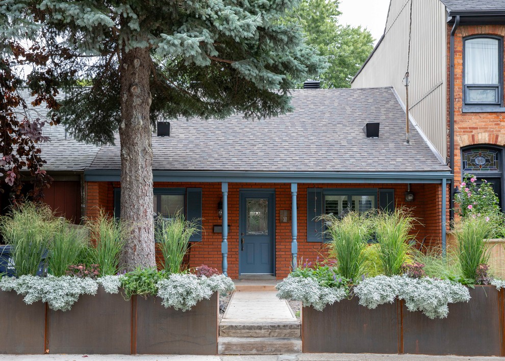 Cette photo montre une façade de maison rouge chic en brique de plain-pied avec un toit à deux pans et un toit en shingle.