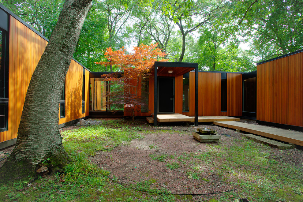 Идея дизайна: одноэтажный, деревянный, коричневый частный загородный дом в стиле ретро с плоской крышей