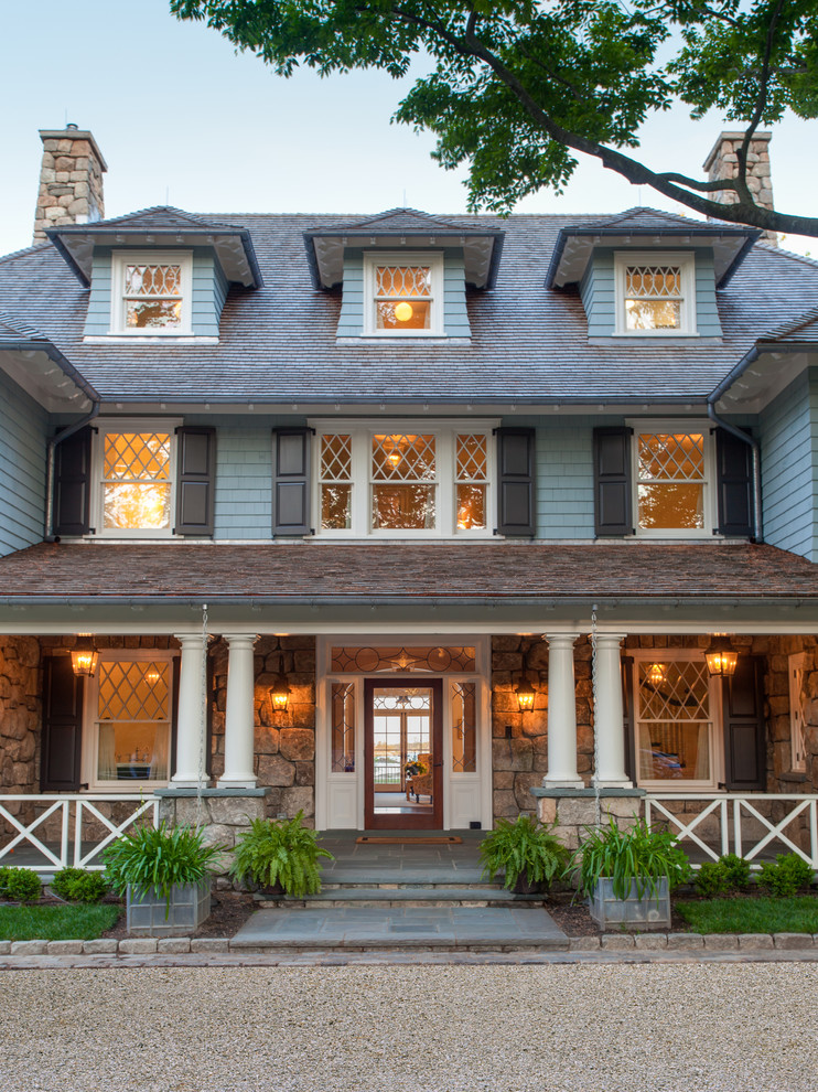 Inspiration pour une grande façade de maison grise traditionnelle en bois à deux étages et plus avec un toit à quatre pans.