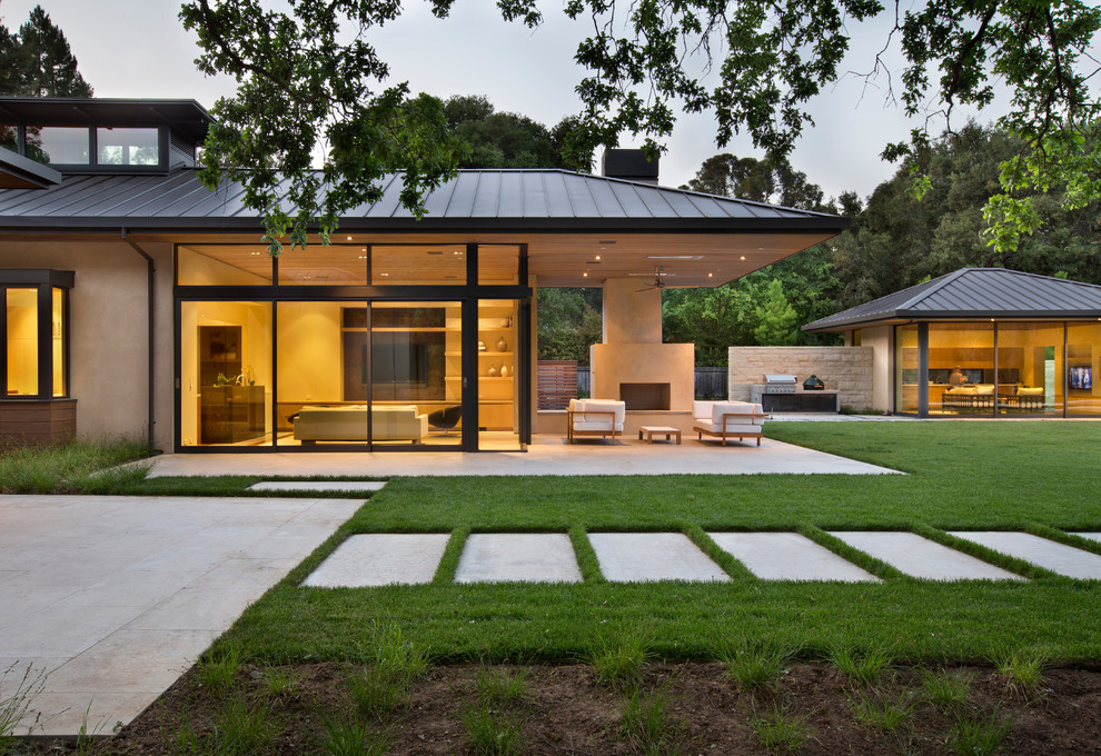 Inspiration pour une façade de maison design en verre de plain-pied avec un toit à quatre pans et un toit en métal.