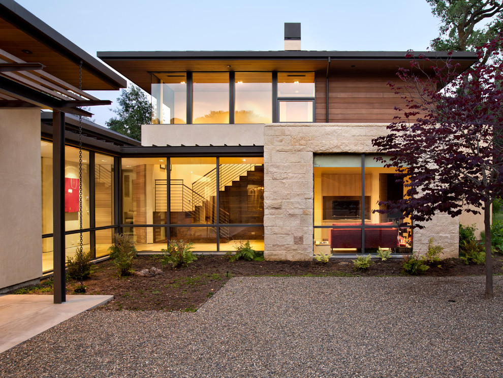 Inspiration pour une grande façade de maison beige design à un étage avec un toit à deux pans et un toit en métal.
