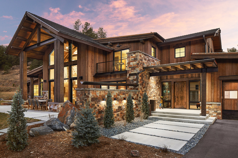 This is an example of a large rustic two floor detached house in Denver with wood cladding.