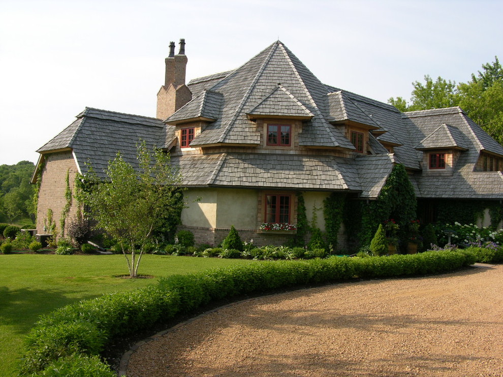 Modelo de fachada beige tradicional grande de dos plantas con revestimiento de estuco y tejado a la holandesa
