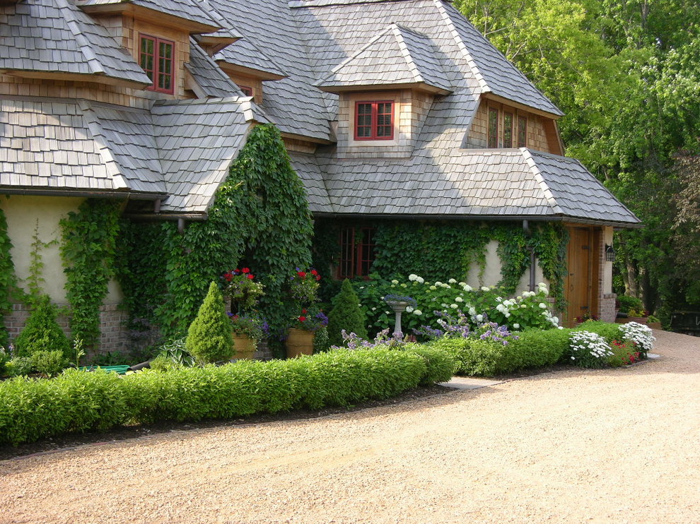 Inspiration pour une grande façade de maison beige traditionnelle en stuc à un étage avec un toit à croupette.