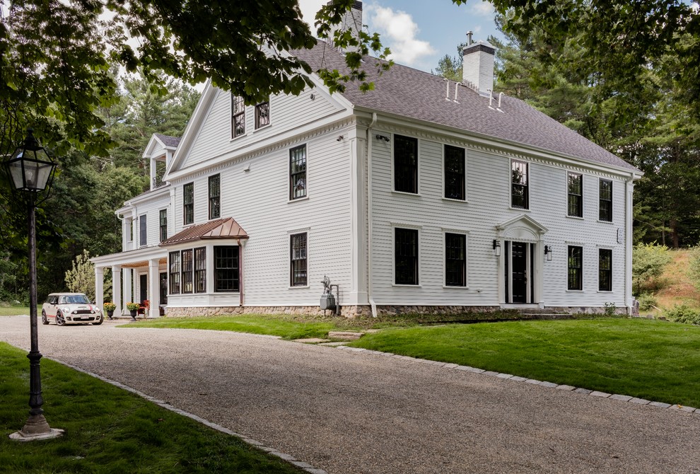 Immagine della facciata di una casa ampia bianca country a tre piani con rivestimento in vinile