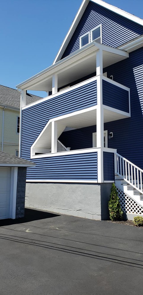 Inspiration för mellanstora moderna blå lägenheter, med tre eller fler plan, vinylfasad, sadeltak och tak i shingel