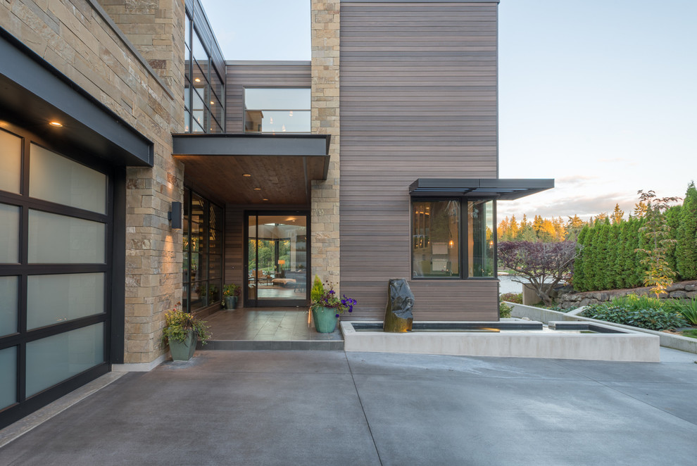 Großes, Dreistöckiges Modernes Einfamilienhaus mit Mix-Fassade, grauer Fassadenfarbe, Pultdach und Blechdach in Seattle