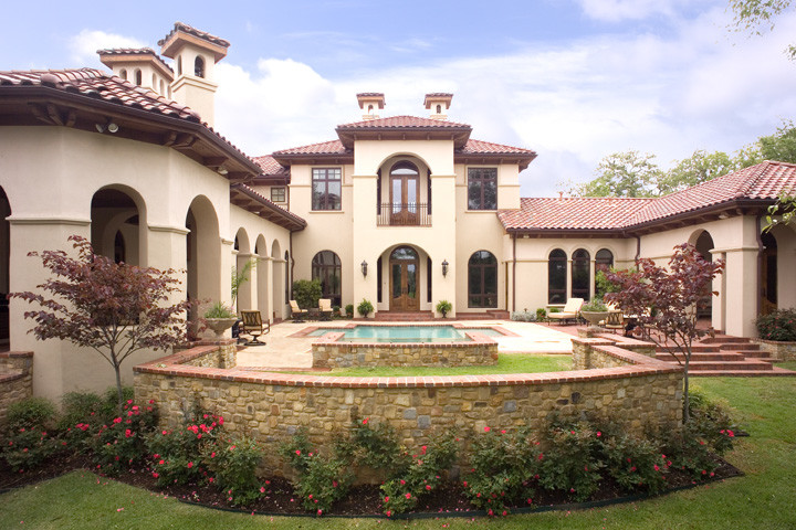 Inspiration for a large mediterranean beige two-story stucco gable roof remodel in Houston