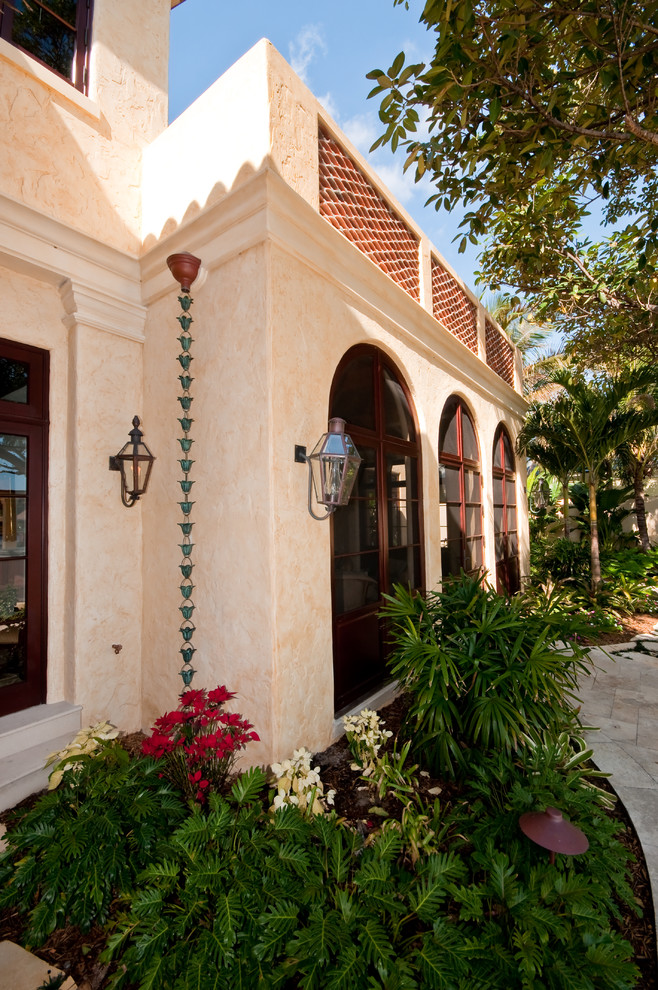 Foto della facciata di una casa grande beige mediterranea a due piani con rivestimento in stucco