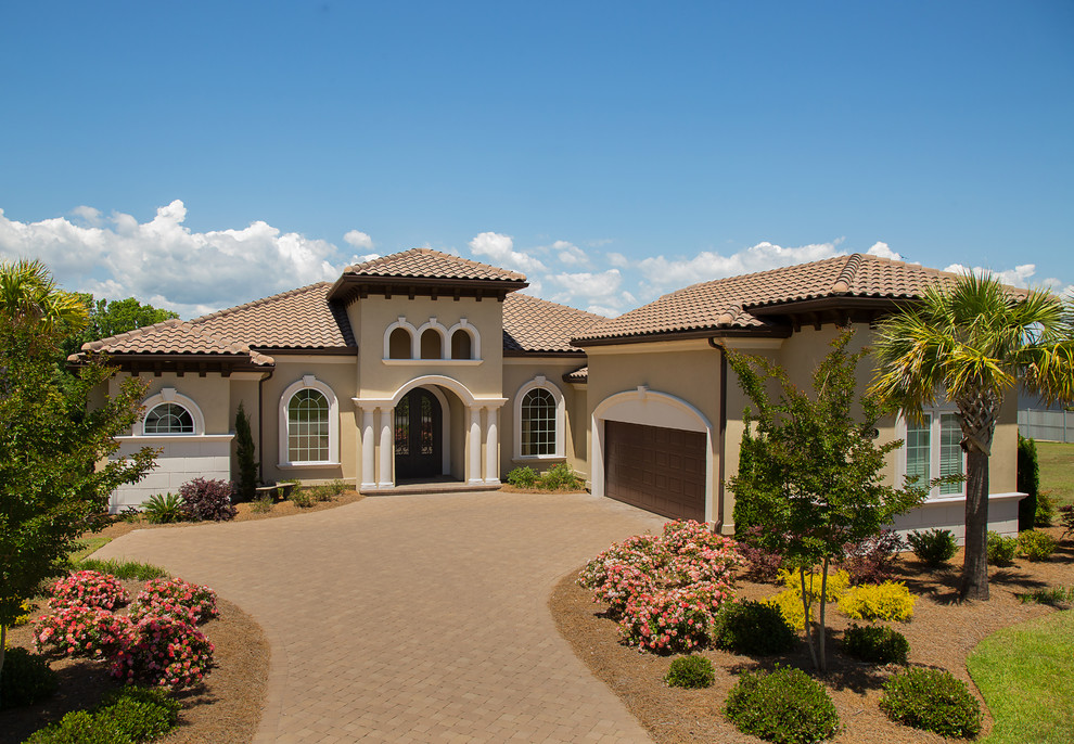 Tuscan beige house exterior photo in Other with a hip roof and a shingle roof