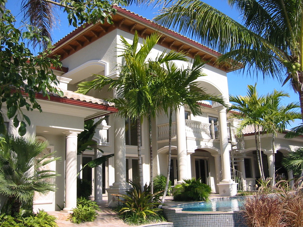 Inspiration for a large mediterranean green two-story stucco exterior home remodel in Miami