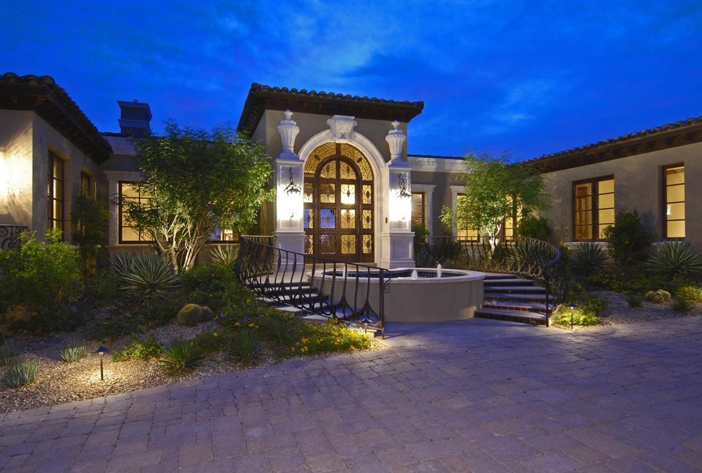 Example of a tuscan beige one-story exterior home design in Other