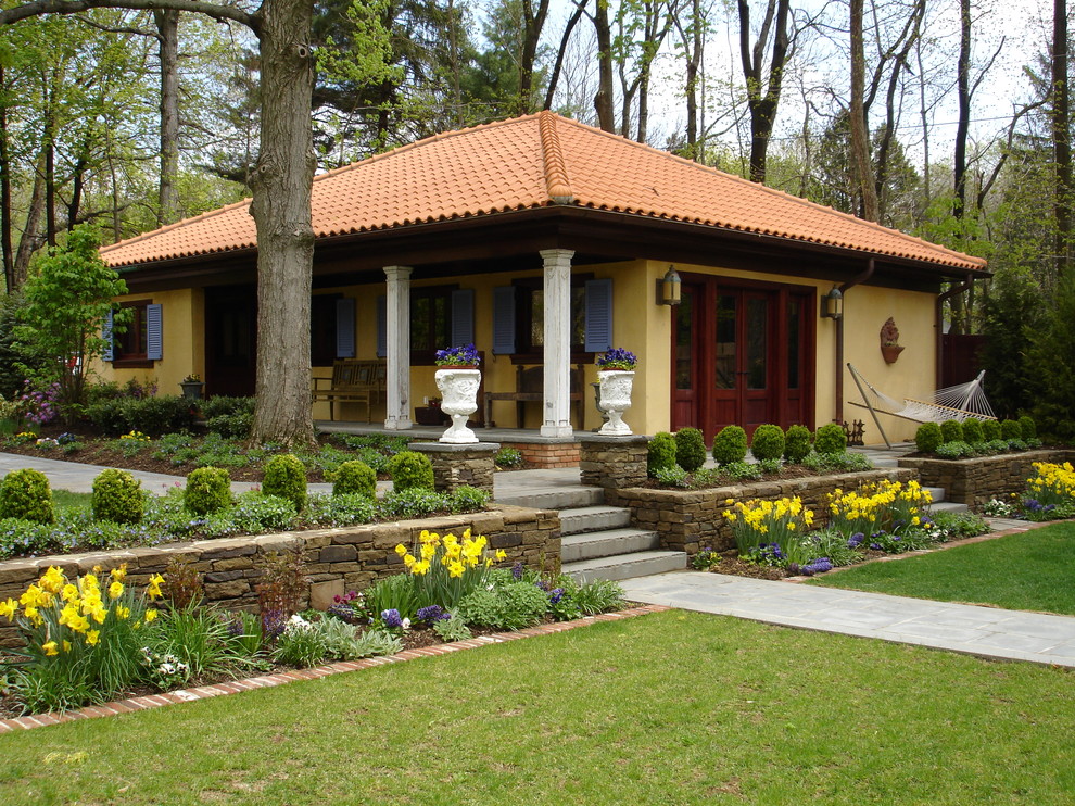 На фото: одноэтажный, маленький дом в средиземноморском стиле для на участке и в саду с