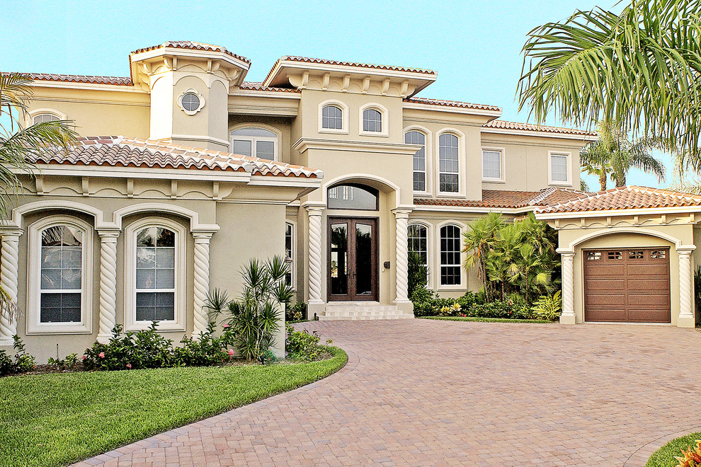 This is an example of a beige mediterranean two floor render house exterior in Tampa.