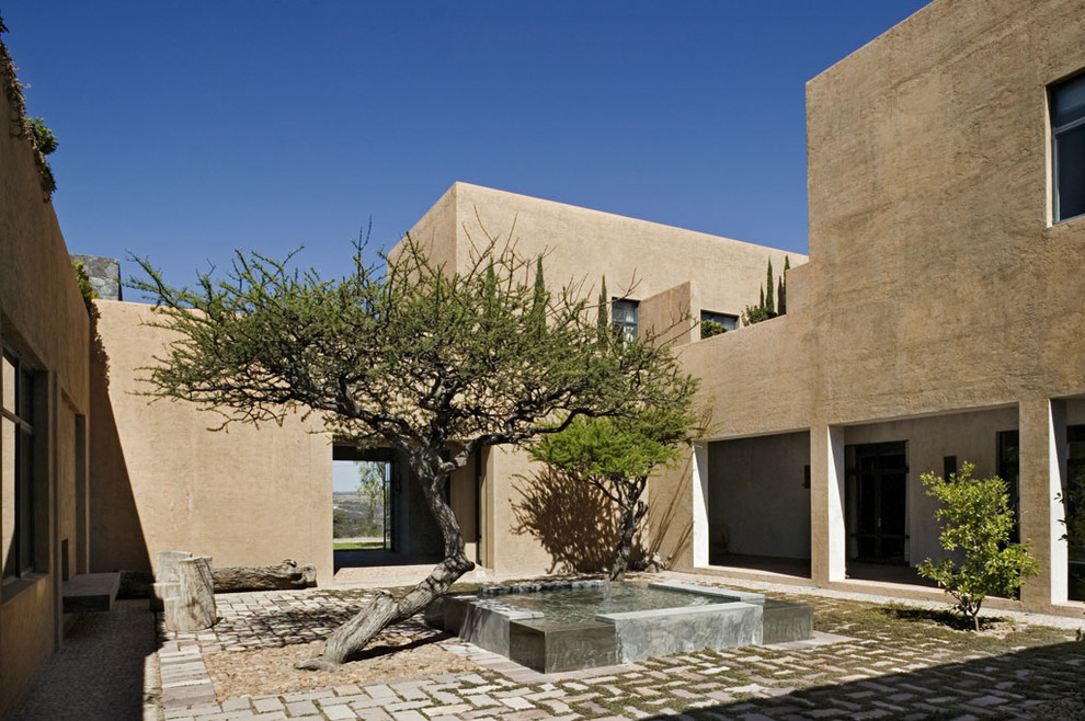 Example of a tuscan two-story flat roof design in New York
