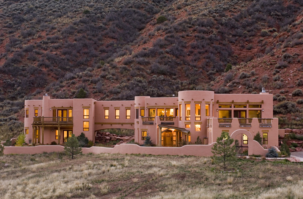 This is an example of an expansive two floor clay detached house in Denver with a flat roof and a pink house.