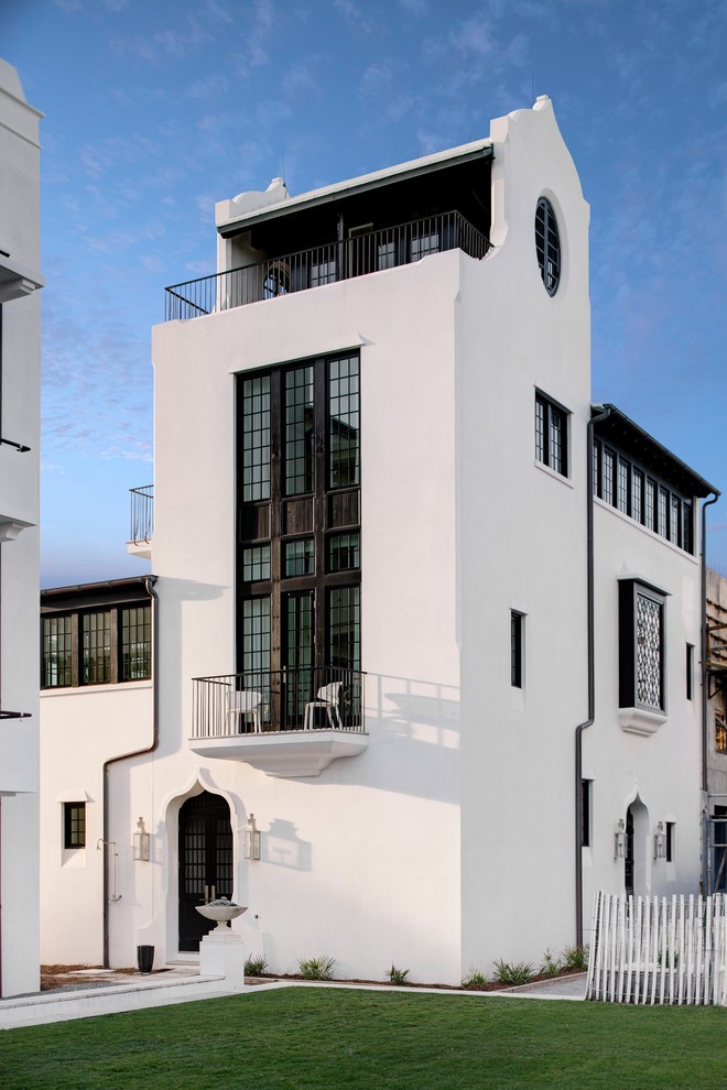 Foto de fachada blanca mediterránea de tres plantas con revestimiento de estuco