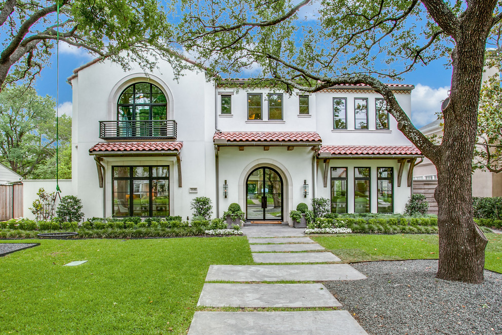 Zweistöckiges Mediterranes Einfamilienhaus mit Putzfassade, weißer Fassadenfarbe und Ziegeldach in Dallas