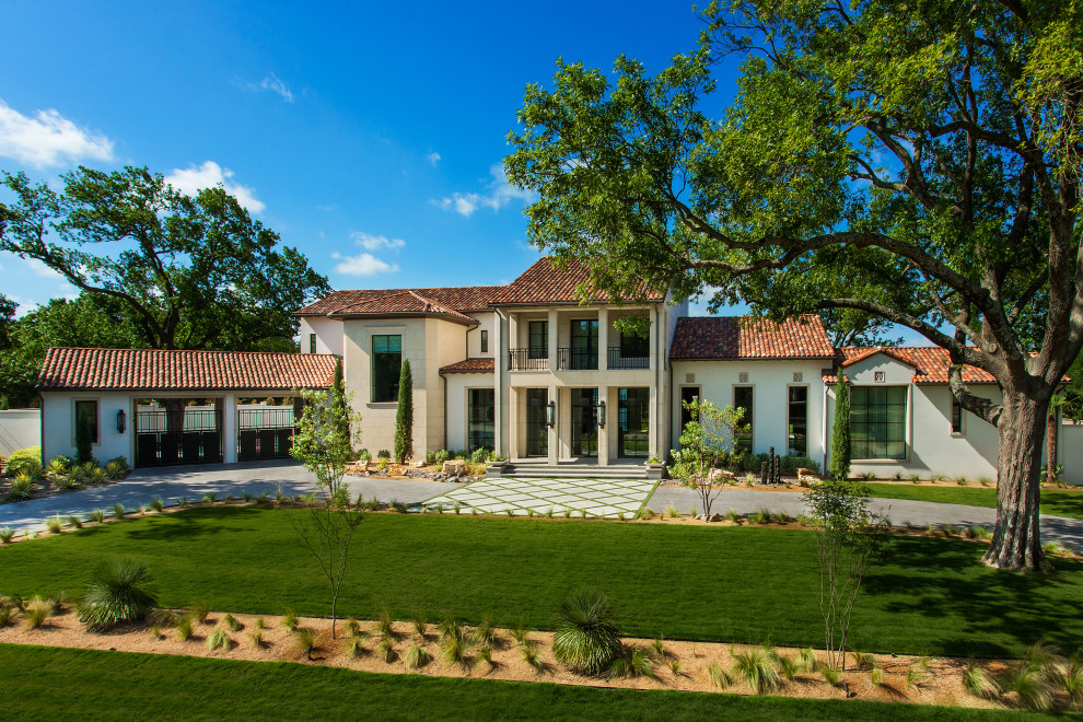 Mediterranean multicolored two-story house exterior idea in Dallas with a hip roof and a tile roof