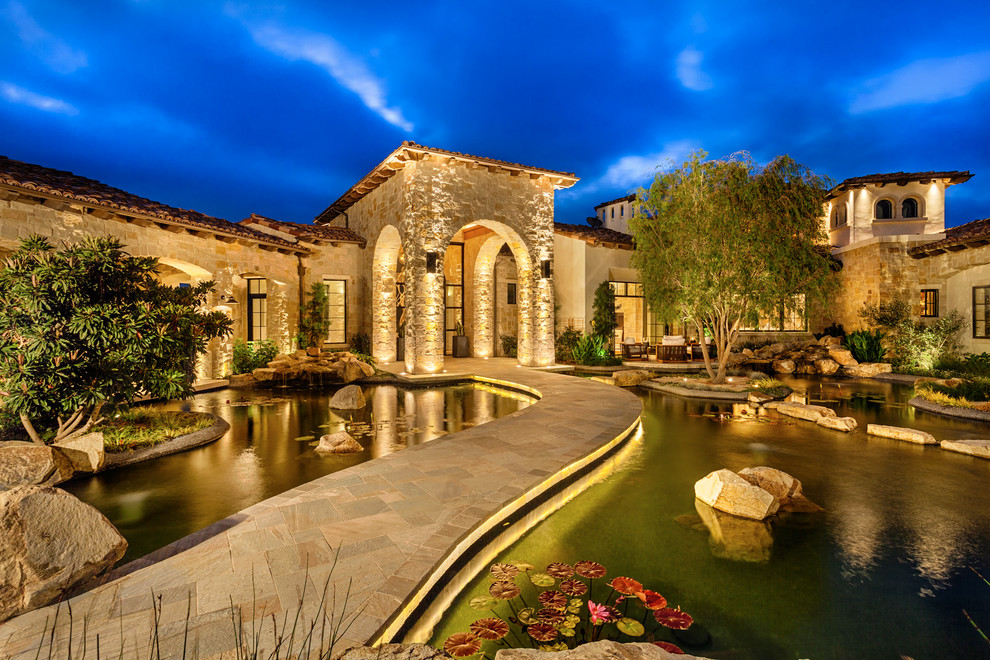 Inspiration for a mediterranean house exterior in San Diego with stone cladding.