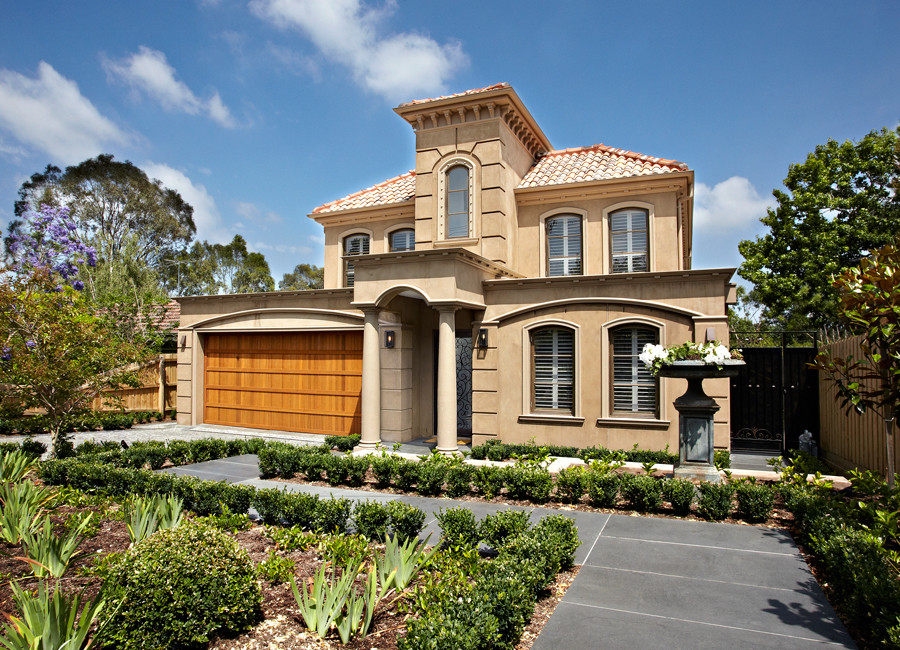 Cette image montre une grande façade de maison beige design à un étage.