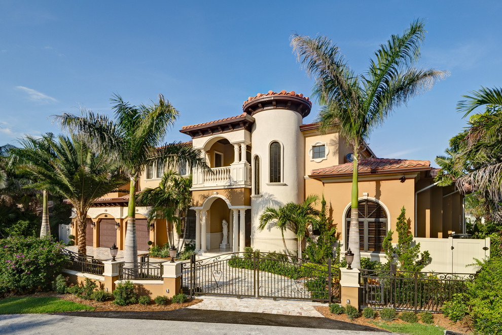 Tuscan beige two-story adobe exterior home photo in Miami
