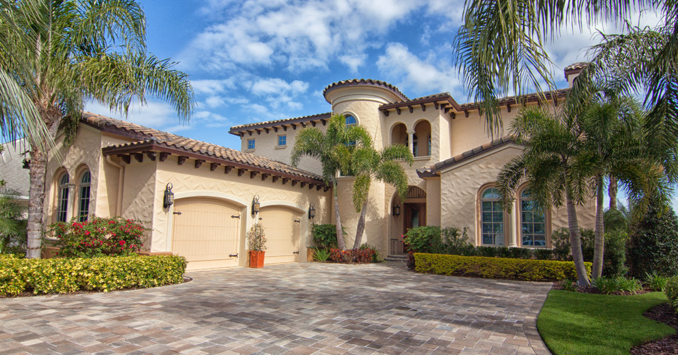 Inspiration for a medium sized and beige mediterranean two floor clay house exterior in Orlando with a half-hip roof.