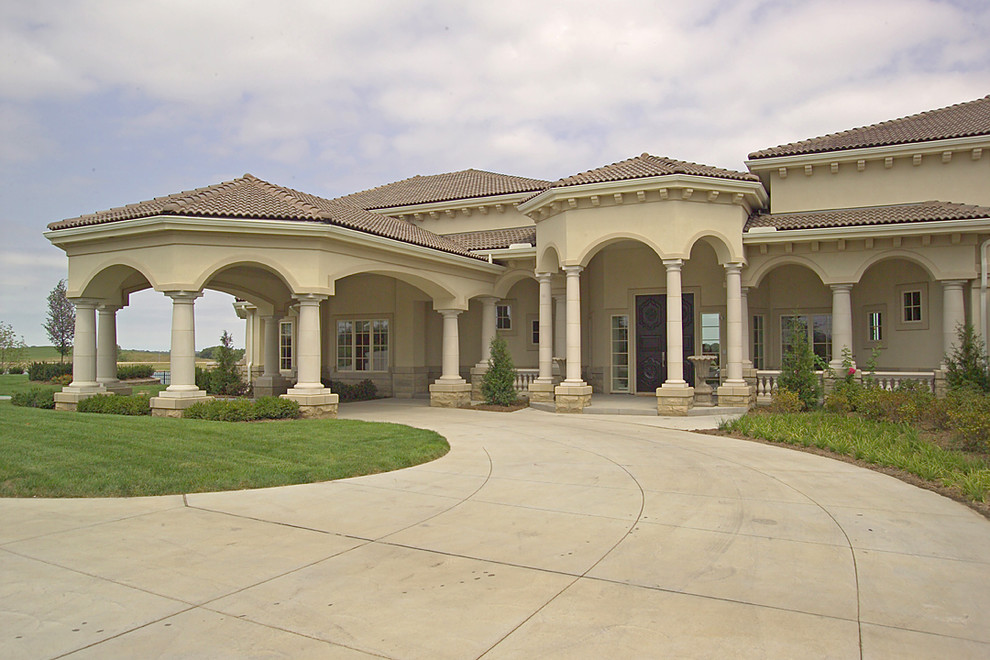 This is an example of an expansive and beige mediterranean two floor render house exterior in Omaha.