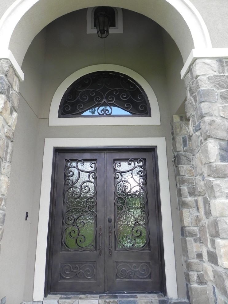 Example of a large tuscan gray two-story stone exterior home design in Houston