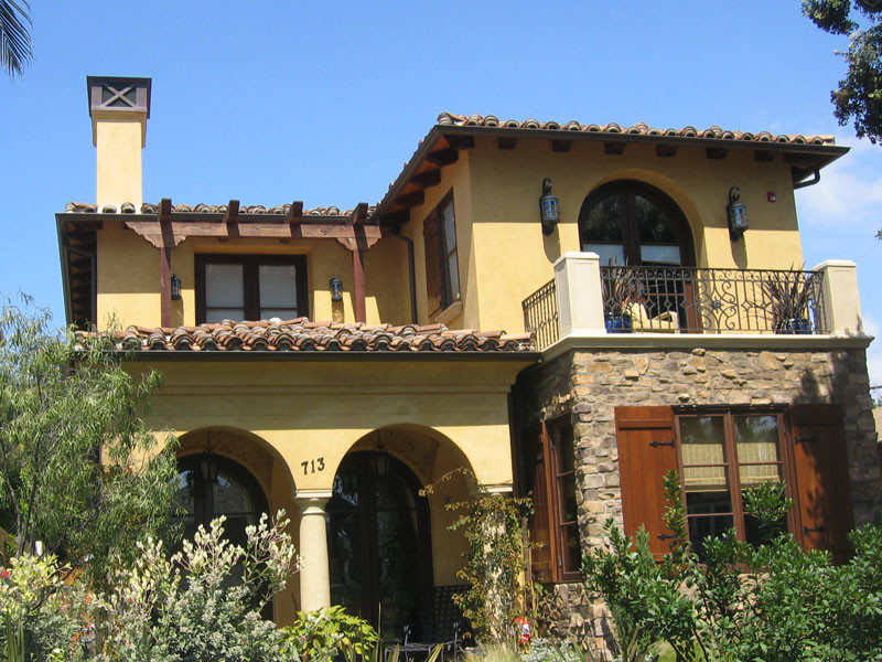 Foto della facciata di una casa gialla mediterranea a due piani di medie dimensioni con rivestimento in stucco e tetto a padiglione