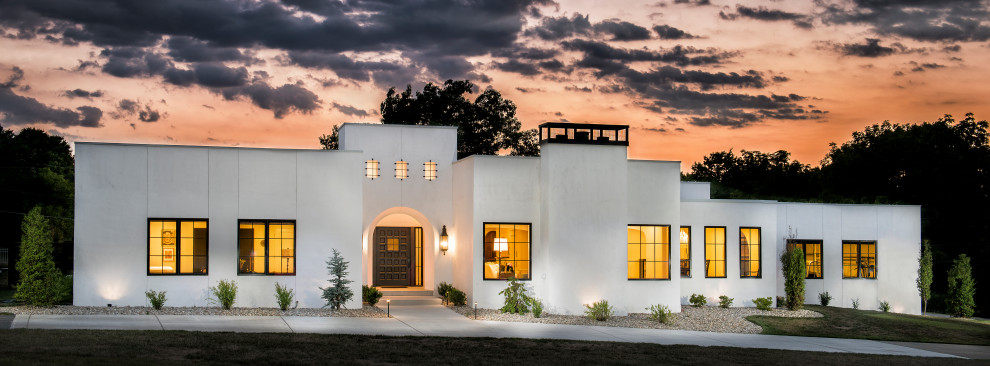 Diseño de fachada de casa blanca mediterránea grande de una planta con revestimiento de estuco y tejado plano