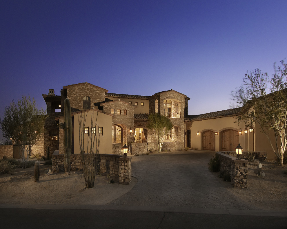 Photo of a mediterranean two floor house exterior in Phoenix with mixed cladding.