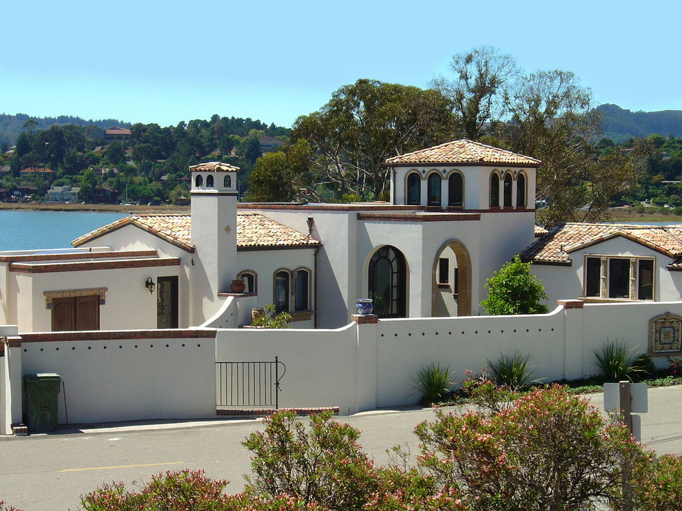 Cette photo montre une façade de maison méditerranéenne à deux étages et plus avec un toit en tuile.