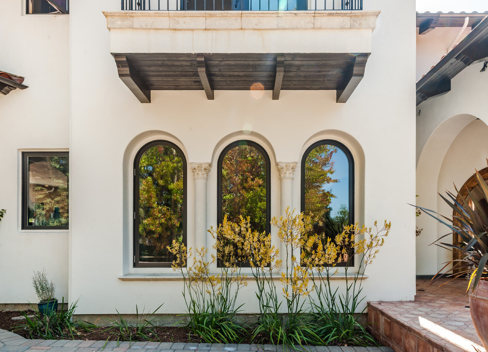 Diseño de fachada beige mediterránea extra grande de dos plantas con revestimiento de estuco y tejado a cuatro aguas