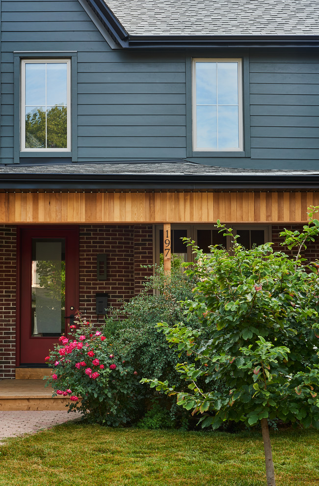 Foto de fachada de casa bifamiliar roja bohemia de tamaño medio de dos plantas con revestimiento de aglomerado de cemento, tejado a cuatro aguas y tejado de teja de madera