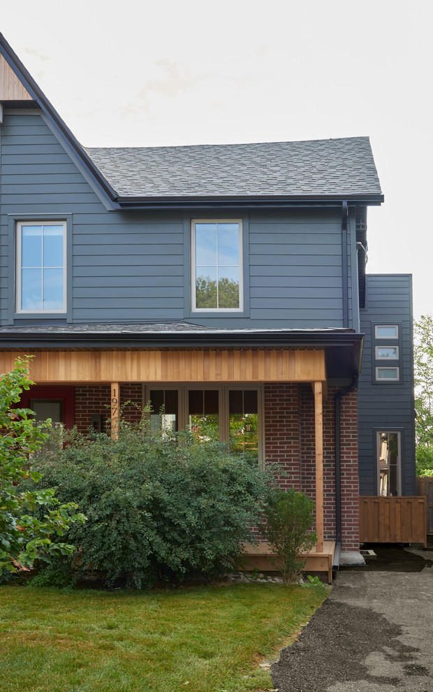 На фото: двухэтажный, кирпичный, синий дуплекс среднего размера в стиле фьюжн с вальмовой крышей и крышей из гибкой черепицы