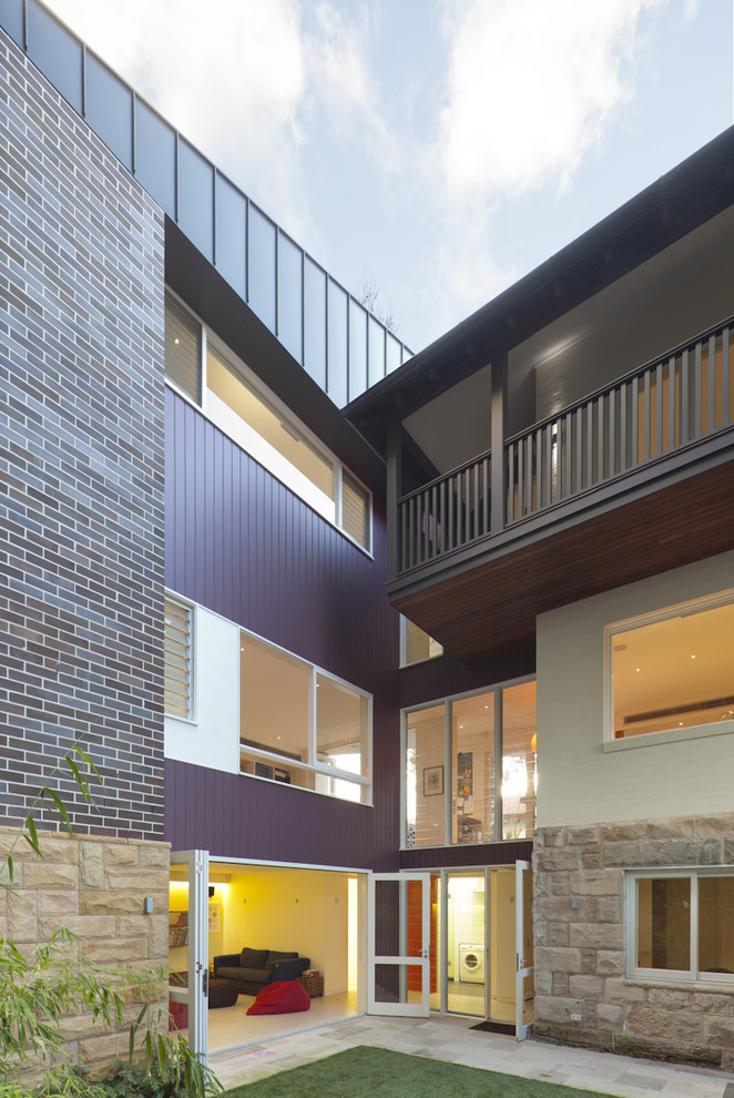 Exemple d'une grande façade de maison multicolore tendance à deux étages et plus avec un revêtement mixte et un toit à quatre pans.