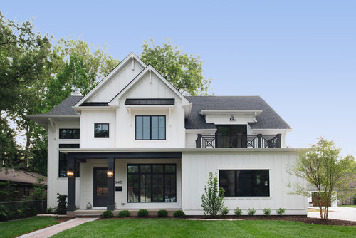 farmhouse white two-story wood exterior home remodel in Chicago with a mixed material roof and a black roof