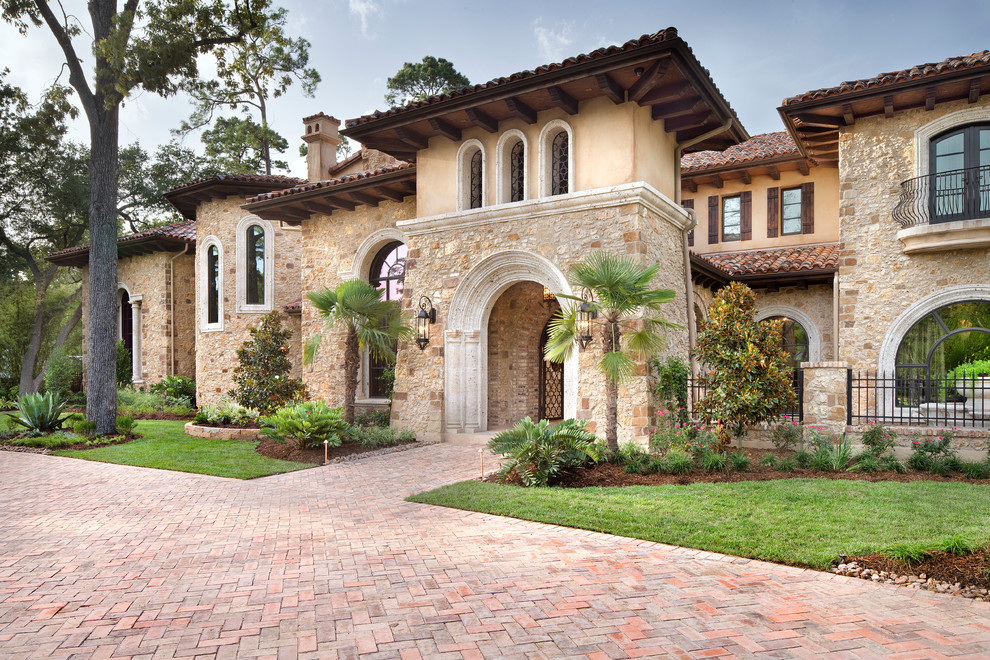 Inspiration for an expansive and beige mediterranean house exterior in Houston with three floors and mixed cladding.