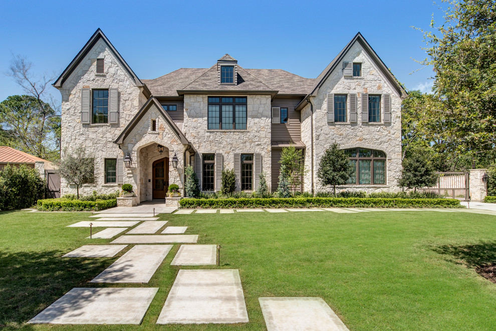 Klassisches Haus mit Steinfassade, beiger Fassadenfarbe und Satteldach in Houston
