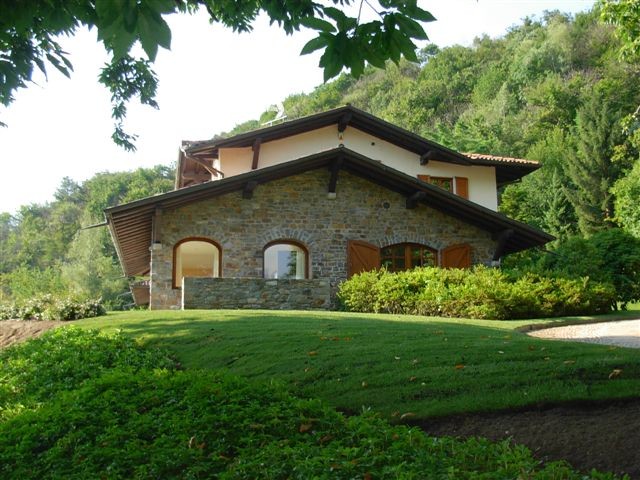 Diseño de fachada beige de estilo de casa de campo extra grande de dos plantas con revestimiento de estuco y tejado a dos aguas