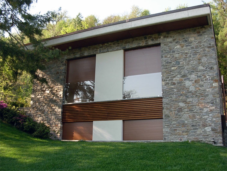 Inspiration pour une très grande façade de maison marron minimaliste en pierre à un étage avec un toit plat.