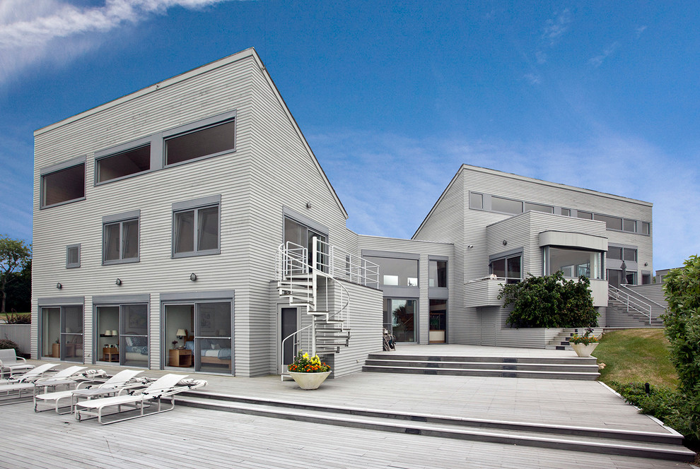 Exemple d'une très grande façade de maison grise tendance à deux étages et plus avec un toit en appentis.