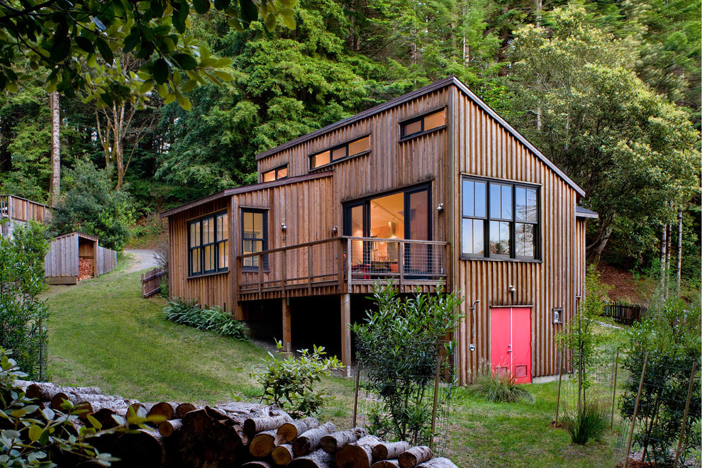 This is an example of a rustic house exterior in San Francisco with three floors, wood cladding and a lean-to roof.