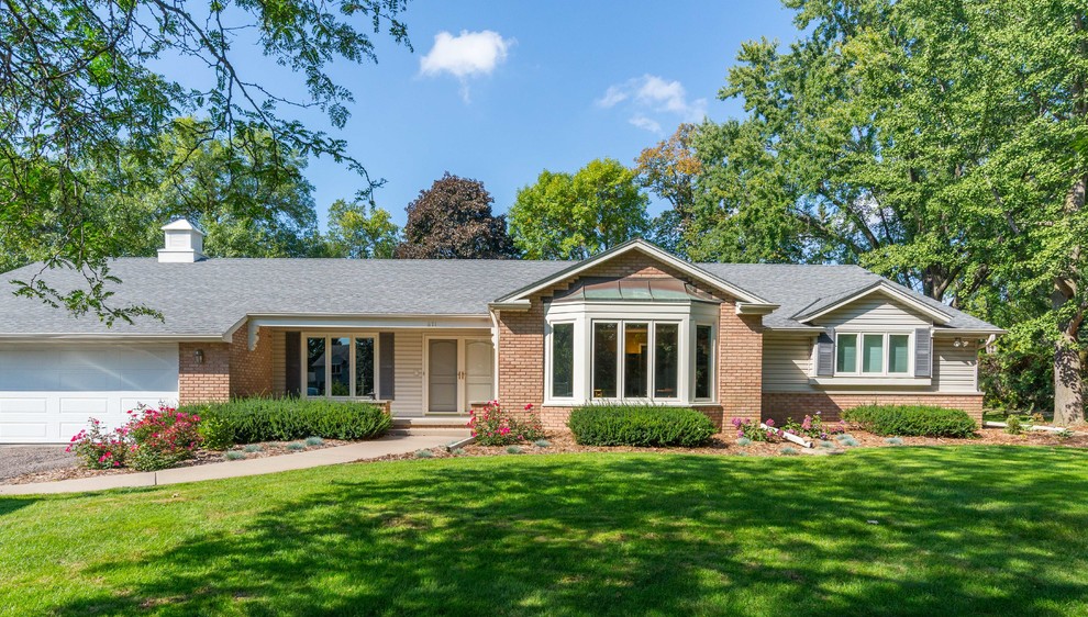 Mid-sized elegant beige one-story brick exterior home photo in Minneapolis with a hip roof